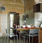 Die moderne Kücheneinrichtung stellt einen spannenden Kontrast zu der zerfallenen Wand dar