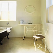 weiße Vintagemöbel im Badezimmer mit schwarzer Clawfoot Badewanne