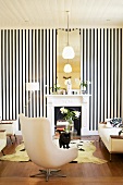 Extravagantes Ambiente im Wohnzimmer mit schwarzweiss gestreifter Tapete, 50er Jahre Spiegel und Kuhfellteppich