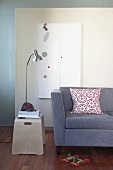Modernes Sofa und Beistelltisch mit Leseleuchte vor abstraktem Gemälde