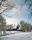 Winterlandschaft mit Bauernhaus im Hintergrund