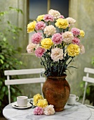 A vase of carnations on a garden table