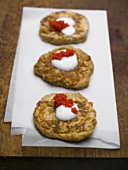 Three blinis with sour cream and red caviar