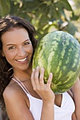 Frau hält eine grosse Wassermelone