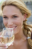 Blonde Frau trinkt ein Glas Weißwein