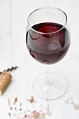 A glass of red wine on a white wooden table