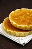 Two amandines (almond tarts) with orange and pine nuts