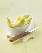 Chicory in a small bowl, kitchen knife beside it