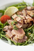 Sliced, grilled tuna on rocket salad