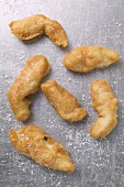 Several deep-fried fish nuggets sprinkled with salt