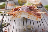 Two sole saltimboccas with ham on skewers