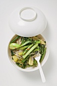 Noodles and vegetables in Asian soup bowl