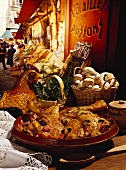 Coq au vin with ingredients, French market in background