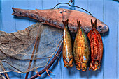 Räucherfische hängen an einem Haken an einem Brett