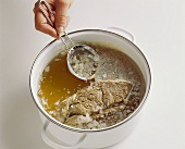 Removing the fat from cold beef stock with a sieve