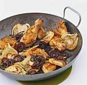 Chicken pieces on fennel and red onions