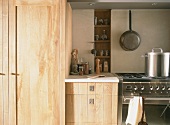 Küchenausschnitt mit Edelstahlherd & Holzschränken