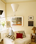 Zimmerecke mit Sofa, Bildern & moderner, mehrarmiger Stehlampe