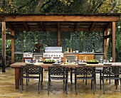 Outdoor-Küche mit gedecktem, länglichem Tisch im Freien