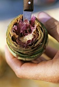 Hollowing out an artichoke with a knife