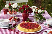 Erdbeertorte, Erdbeeren mit Zuckerguss und Kaffee auf Gartentisch