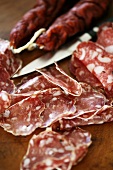 Italienische Salami, ganz und in Scheiben geschnitten