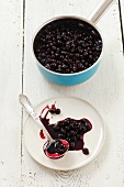 Chokeberry jam in a pot and on a plate