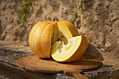 A sliced pumpkin in front of a stone wall