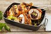 A chicken stuffed with grapes and raisins in a roasting tin