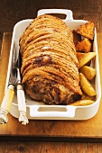 Roast pork with a side of vegetables in an oven-proof dish