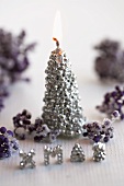 A Christmas candle and writing made of edible pearls with frosted berries