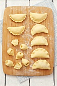 Various types of ravioli on a chopping baord, seen from above
