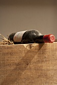 A bottle of red wine with a label on a wooden crate
