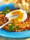 A poached egg on a lentil-vegetable medley