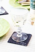 A white wine glass on a slate coaster used also as a name card
