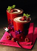 Two glasses of chocolate mousse with berries and mints