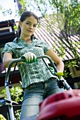 A young woman with a lawn mower