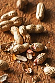 Erdnüsse auf Holzuntergrund (Nahaufnahme)
