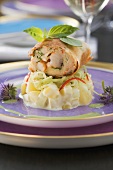 Prawns baked in spring roll dough on a potato and cucumber salad