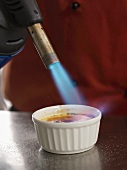 Vanilla cream being caramelised with a blow torch
