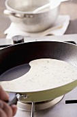 A herb pancake being fried