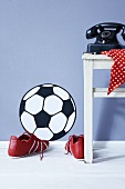 A football wall sticker, football boots and an old telephone