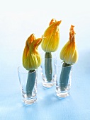 Three courgette flowers in glasses