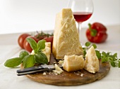 Ein Stück Parmesan mit Messer und Basilikum
