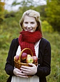 Woman holding basket of freshly picked apples