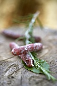 Mini-salami on rosemary and bay leaf