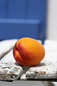 Eine Aprikose auf Gartenstuhl