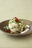 Couscous with vegetables, fried bacon and yoghurt sauce