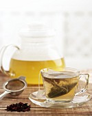Herbal tea in a teapot and a glass cup and saucer