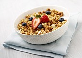 A bowl of granola with fresh berries and milk